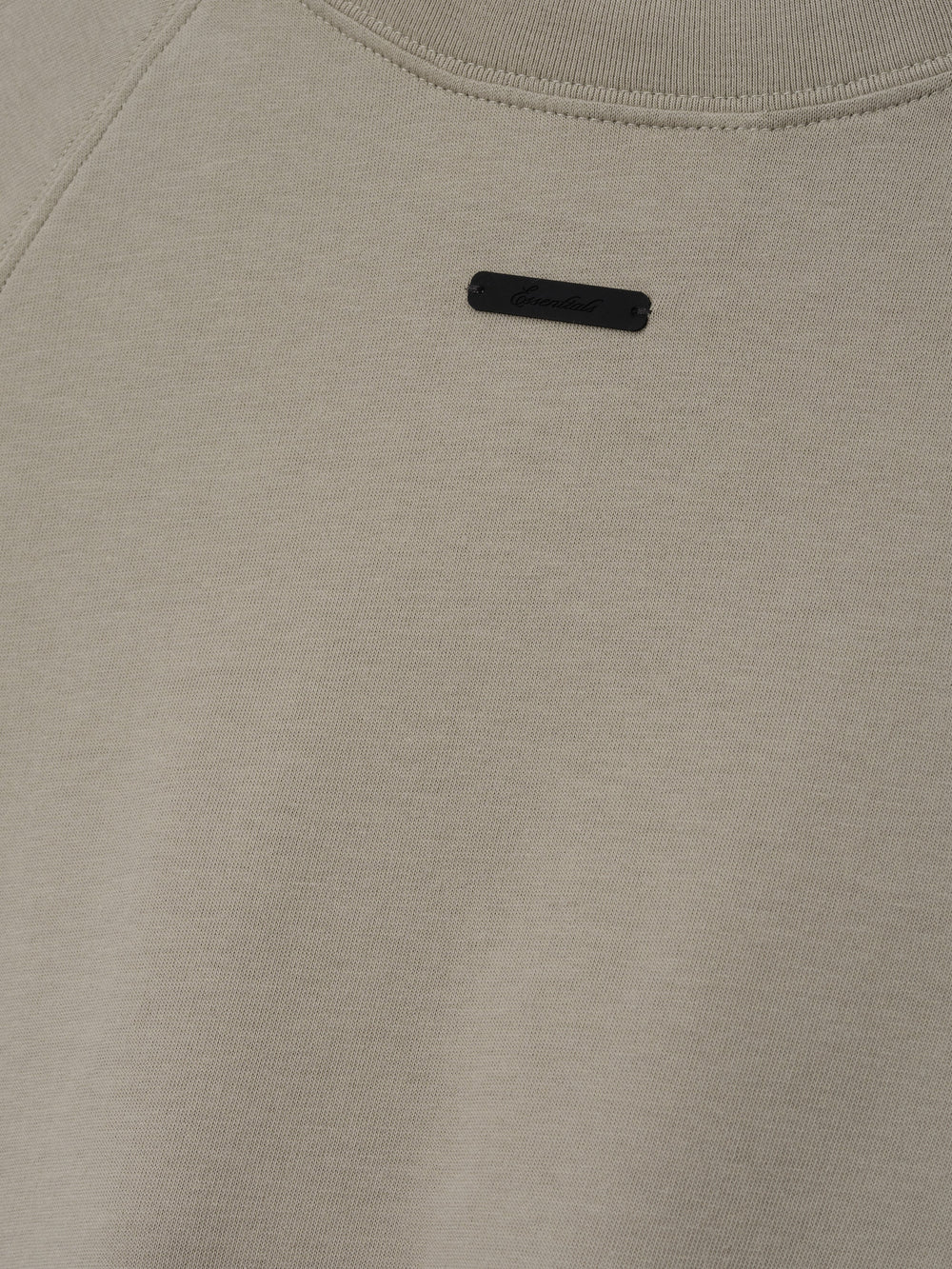 Womens Shrunken Baseball Tee in a muted seal green shade featuring a minimalist black branded patch on the upper back, crafted from soft fabric for casual tops.