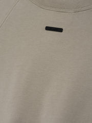 Womens Shrunken Baseball Tee in a muted seal green shade featuring a minimalist black branded patch on the upper back, crafted from soft fabric for casual tops.