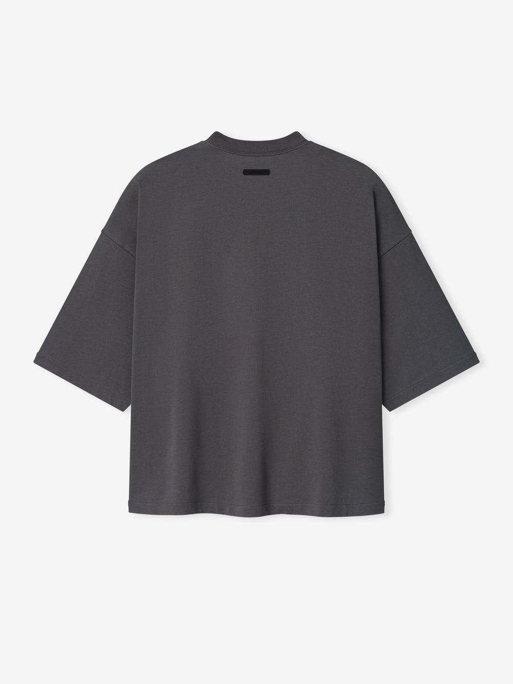 Merch Tee in dark grey featuring an oversized relaxed fit with dropped shoulders and a small black rectangular detail near the neckline for a minimalist casual top.