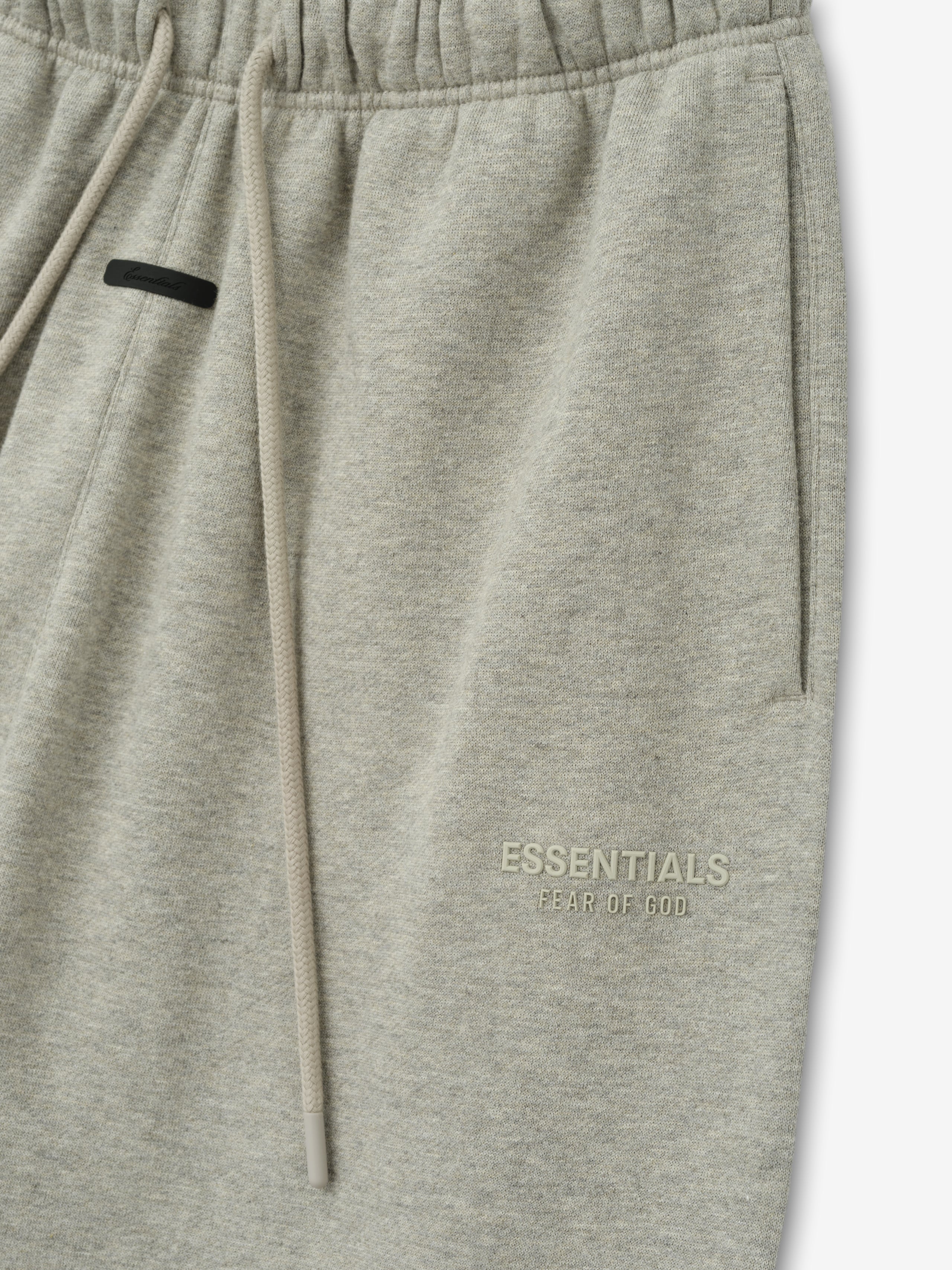 Womens Essentals FW26 Classic Sweatpant close view in light gray fleece with drawstring waistband side pocket and subtle ESSENTIALS Fear of God logo Bottoms