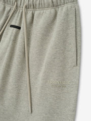 Womens Essentals FW26 Classic Sweatpant close view in light gray fleece with drawstring waistband side pocket and subtle ESSENTIALS Fear of God logo Bottoms