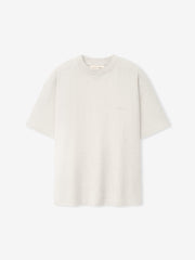 Essentials FW26 Classic Tee in off white shown flat with short sleeves crew neckline and subtle tonal chest logo on a clean background Tops