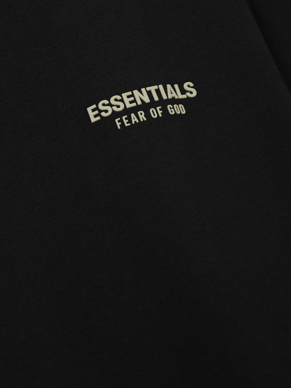 Essentials FW26 Classic Tee close up of black fabric featuring a cream Essentials Fear of God logo detail with soft texture Tops